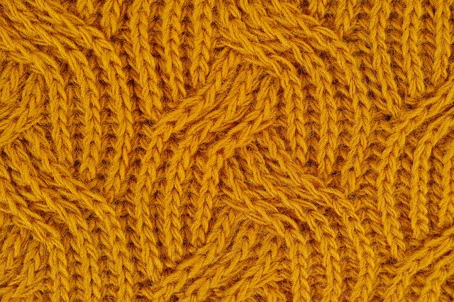 Eine Detailaufnahme eines gelb gefärbten Stoffes als Symbol.