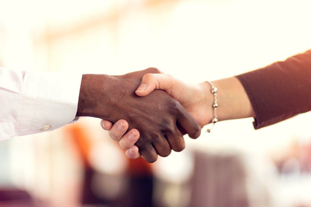Ein Handschlag mit geschäftlichem Hintergrund.