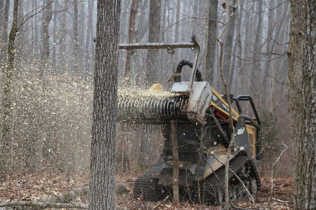 Maschine häckselt Holz im Wald.