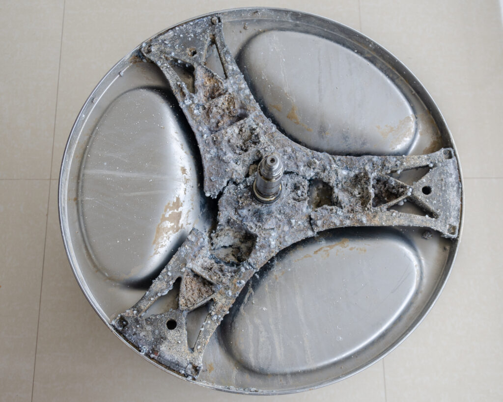 Die verrostete Aluminiumspinne einer Waschmaschine. Korrosionsschutz ist für eine längere Lebensdauer von Bauteilen wichtig.